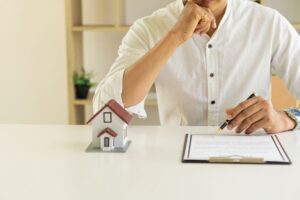 Businessmen holding pens, signing home titles with insurance, care about real estate services
