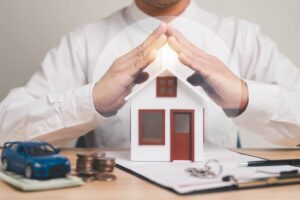 Businessman protecting his assets, represented by a miniature house